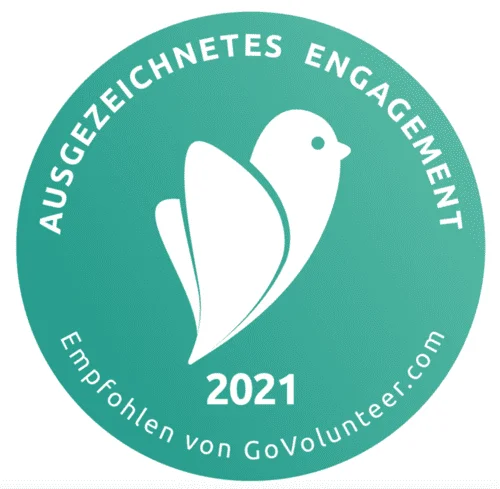 Ein kreisrundes mintfarbenes Symbol mit einem weißen Vogel als Icon in der Mitte und der Zahl 2021 untendrunter. Im Symbol liest man Ausgezeichnetes Engagement und empfohlen von govolunteer.com. Dieses Bild findet man auf der Webseite vom Bundesverband Burnout und Depression.