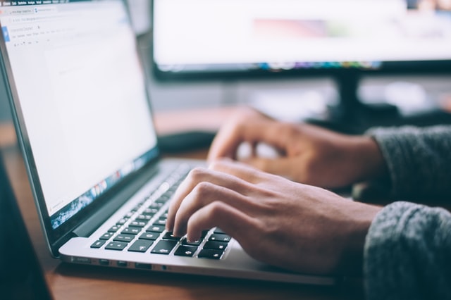 Zwei helle Hände auf einer Laptop Tastatur, bereit zu tippen. Im Hintergrund ein schwarzer heller Bildschirm. Dieses Bild findet man auf der Webseite vom Bundesverband Burnout und Depression.